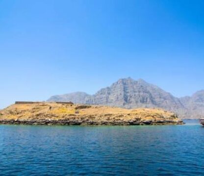 View of Kumzar and Telegraph Island in Oman with turquoise sea and rocky fjords